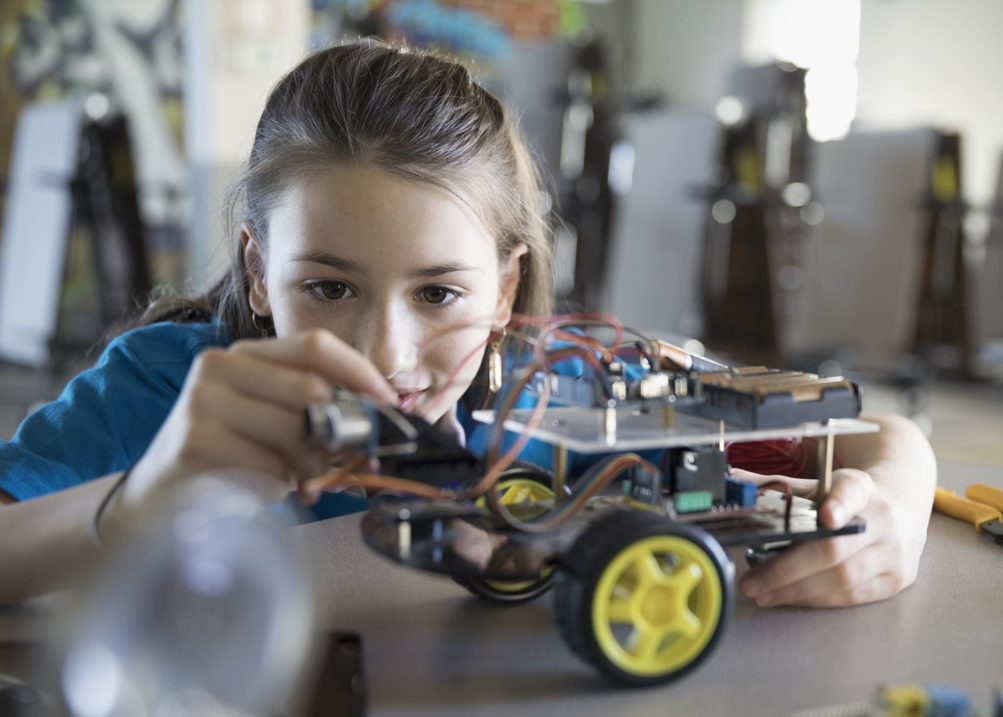 middle school girl working on car robot