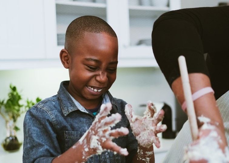 child cooking with flour all over hands